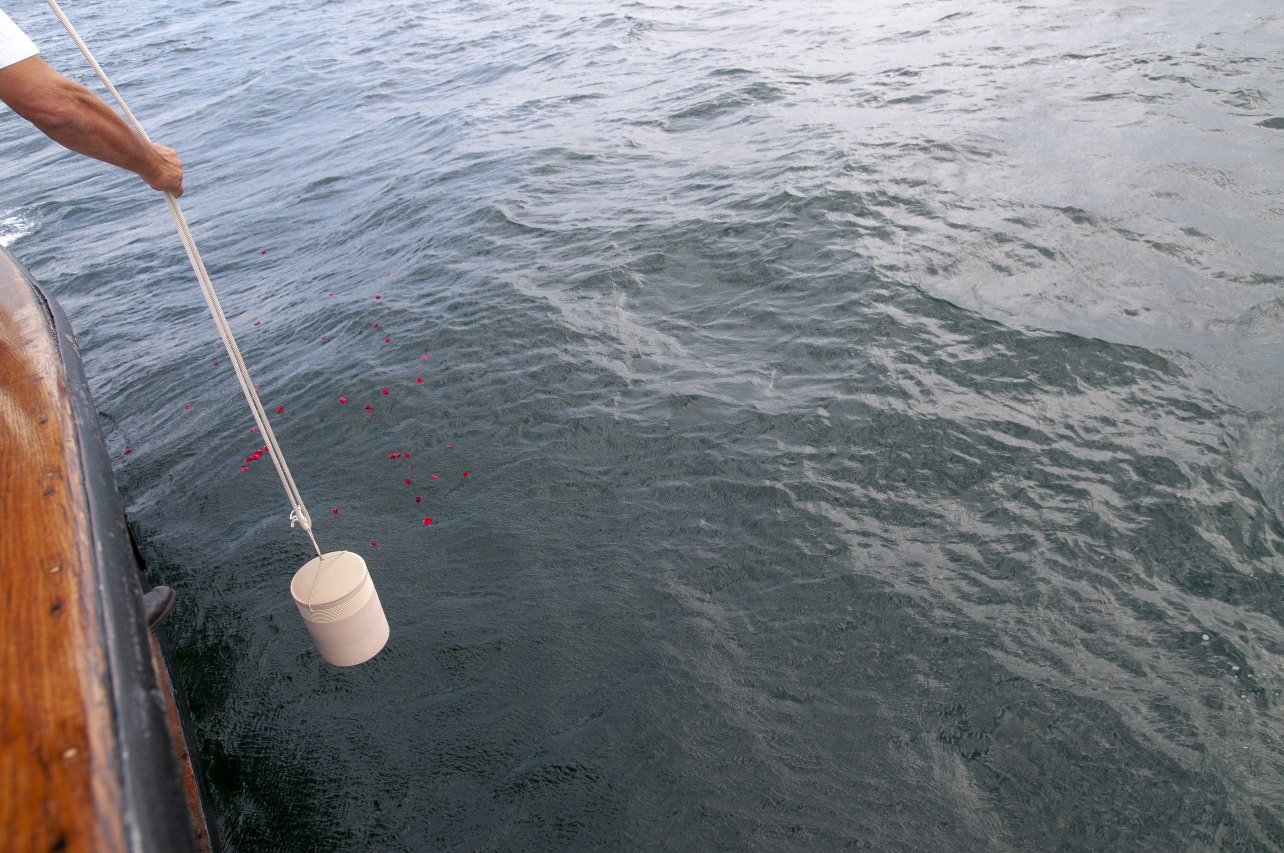 Bestattung auf hoher See, eine Urne mit den sterblichen Überresten wird dem Meer übergeben
